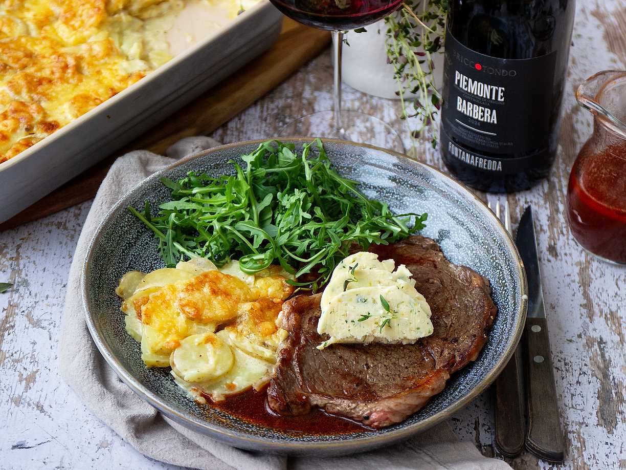 Entrecote med potatisgratäng, örtsmör och rödvinssås