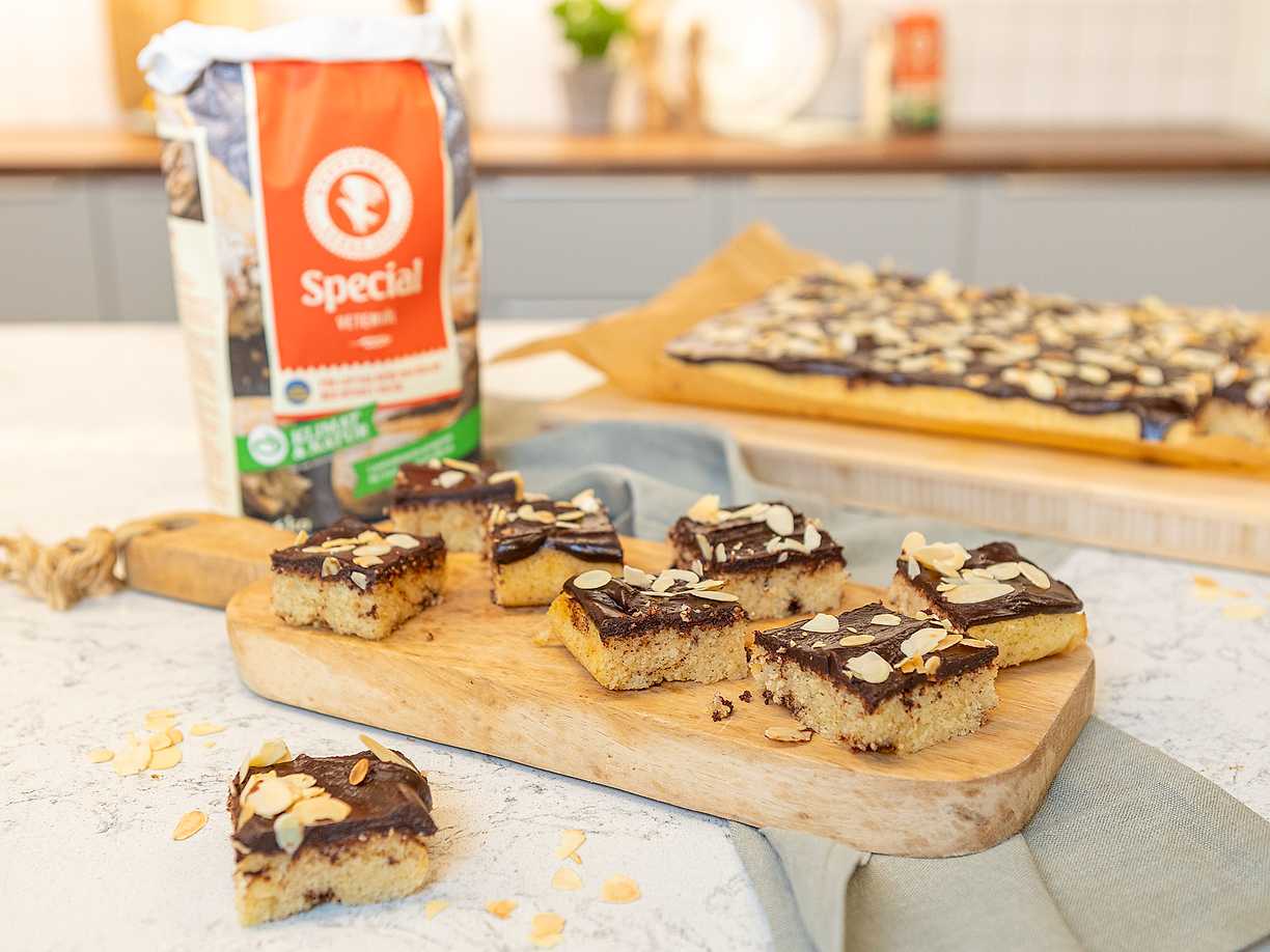 Kanelbullekaka i långpanna med chokladfrosting och mandel