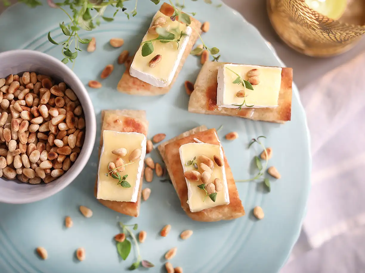 Snittar med brieost, honung och pinjenötter