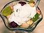 Blandad fruktsallad toppad med yoghurt och mynta
