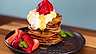 Servera bananpannkakorna med en klick grädde och färska bär